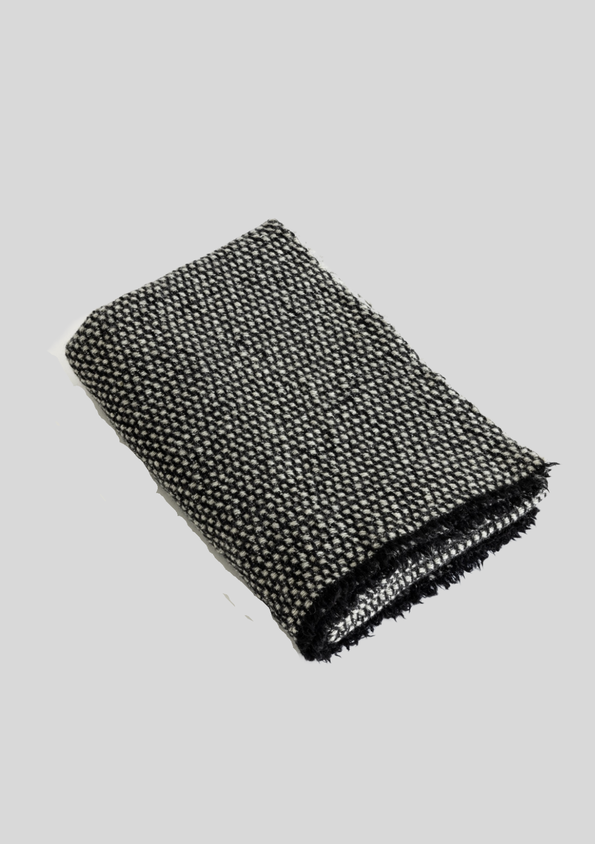 Textured pattern grey and black colored throw made out of responsible sheep wool. Manufactured in Finland.