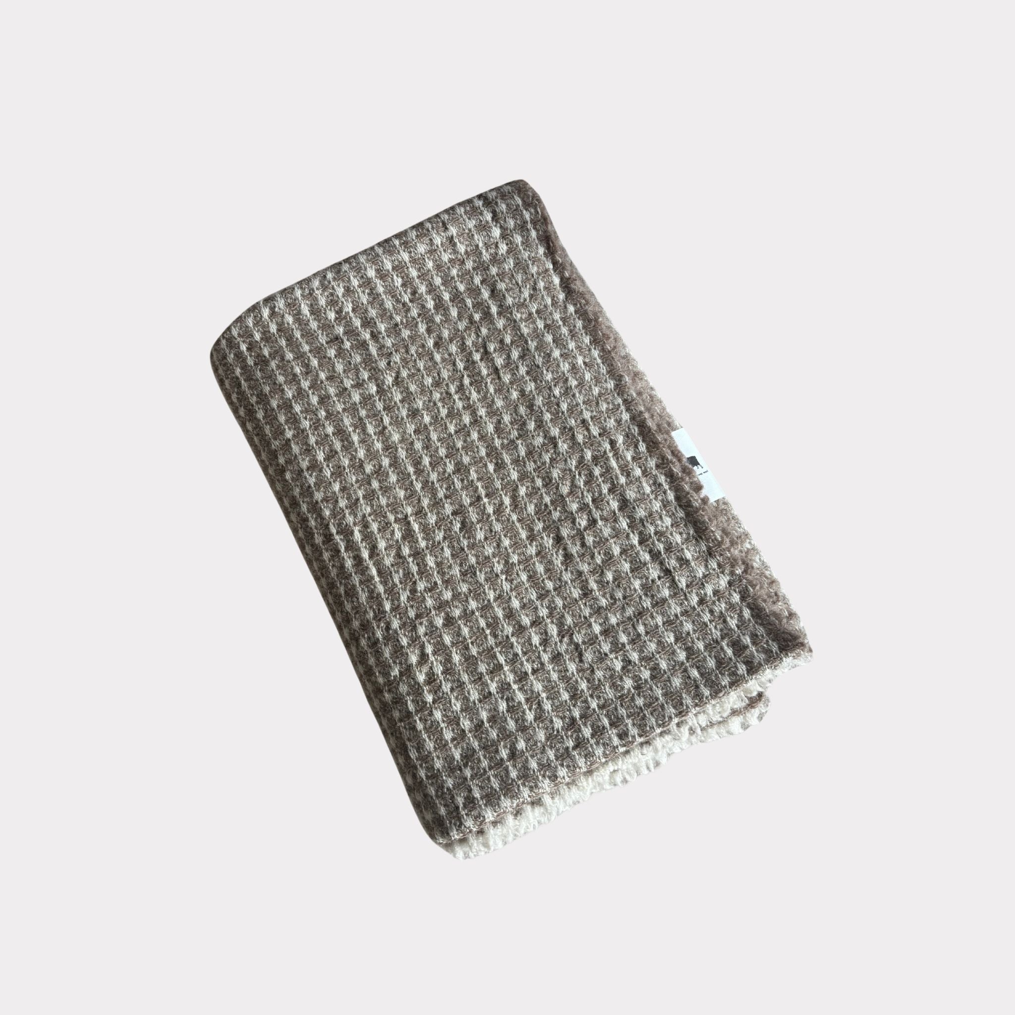 Goose eye Finnish wool blanket from Ekta Helsinki in beige and white. Manufactured responsibly in Finland. Use for outside or inside both summer and winter.