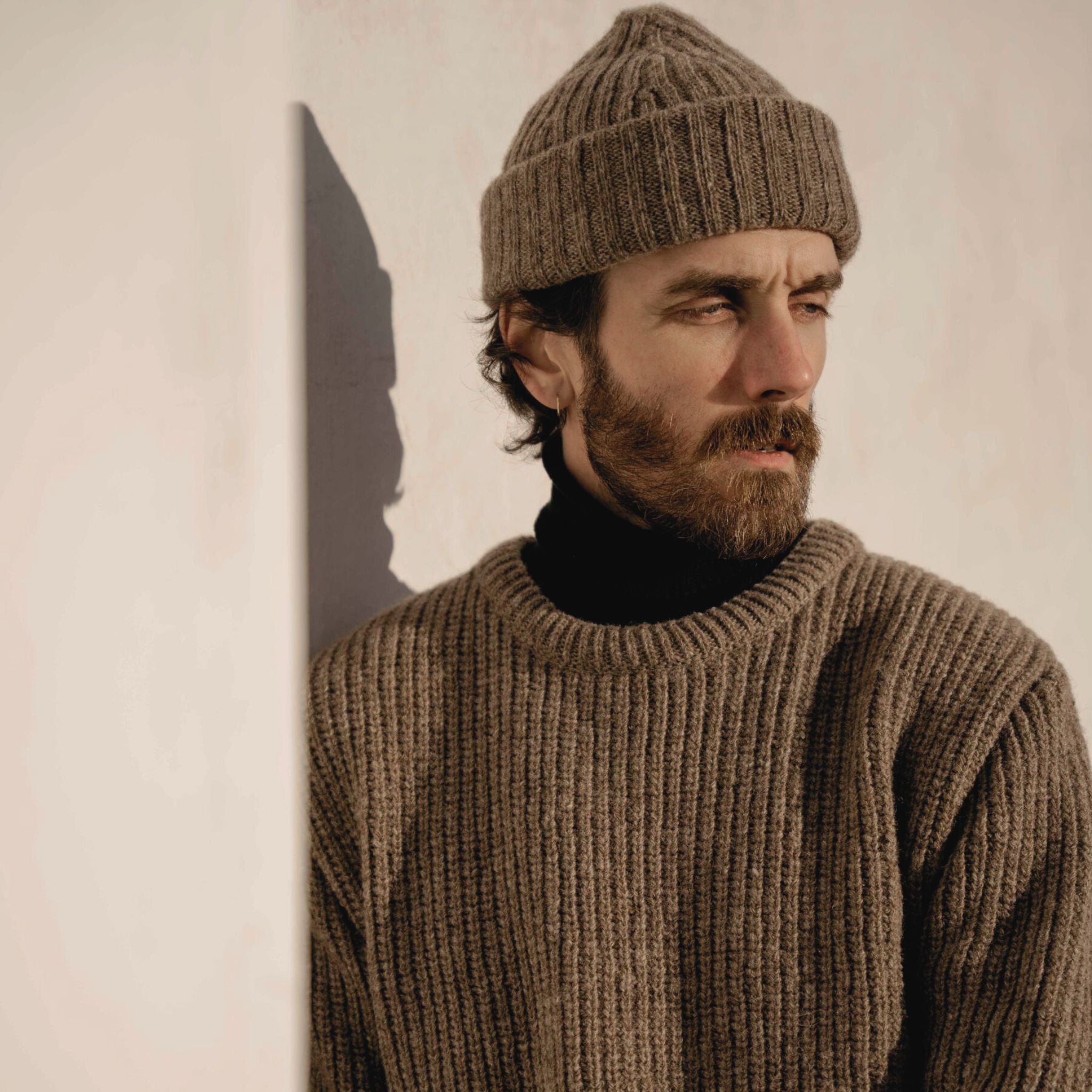 Soft beige knit sweater with round neckline, made from ethically sourced Finnish wool.