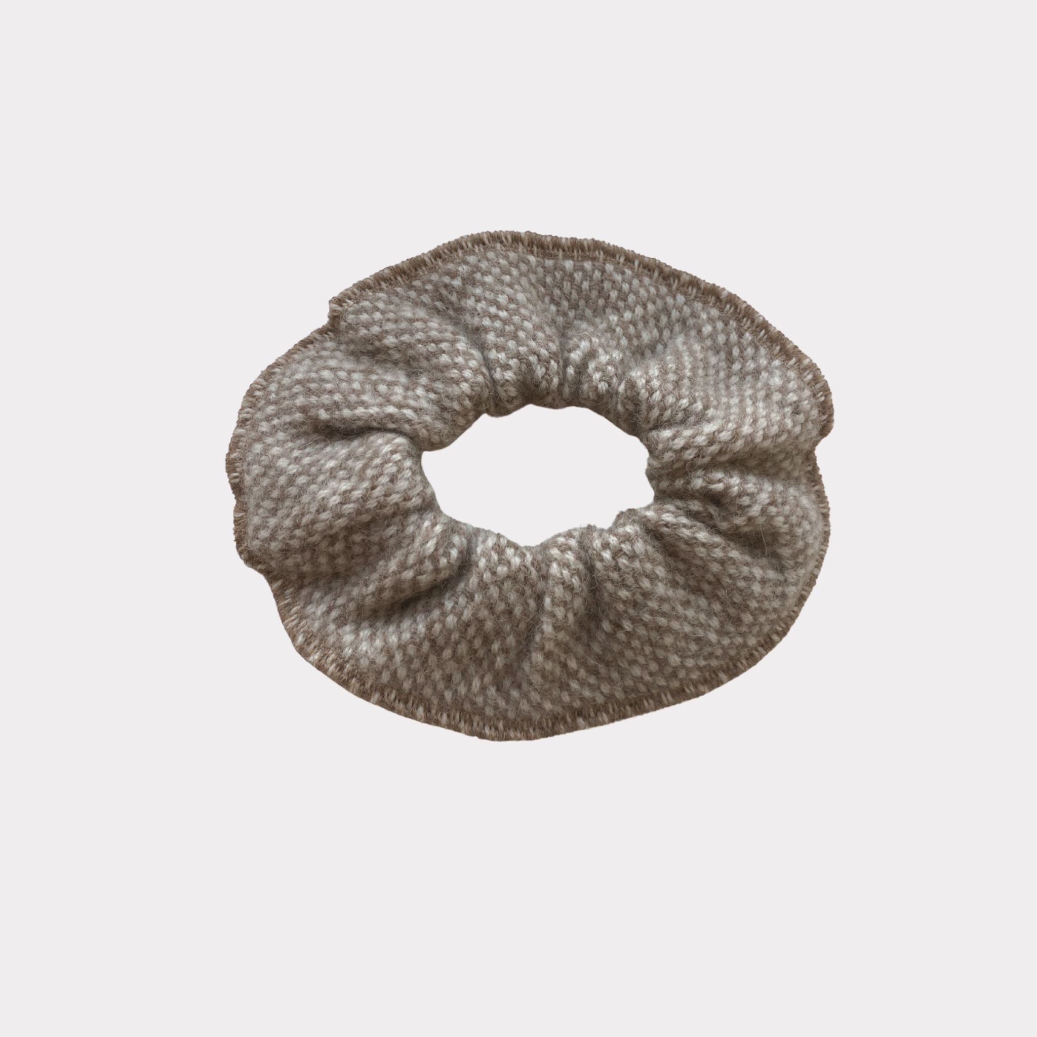 Wool scrunchie that is gentle and warm for the hair and head. Made in Helsinki, material Finnish sheep wool. Comes in beige tones in a checkered and dotted pattern.
