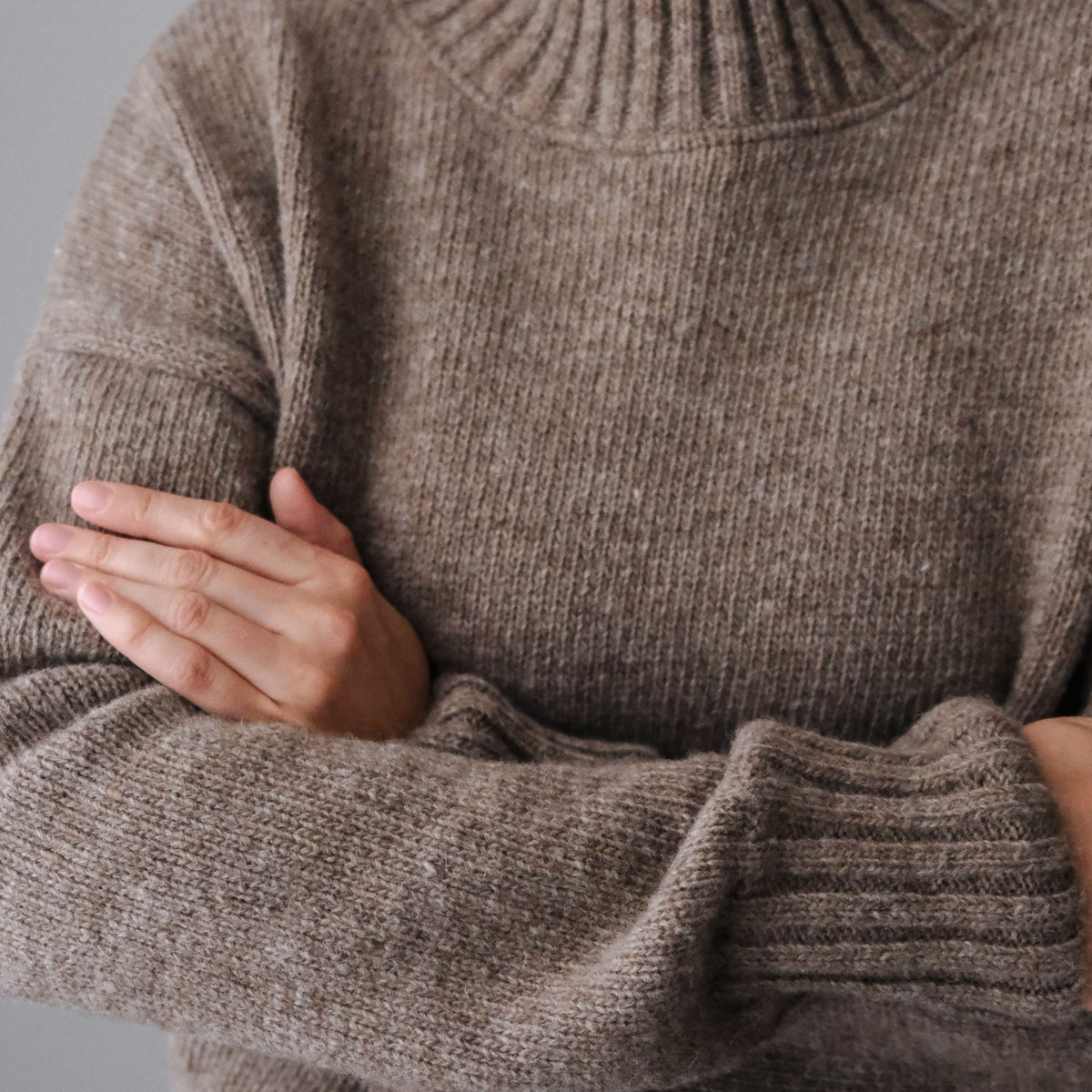 Beige responsible funnel-neck knit made out of Finnish sheep wool, manufactured in Finland.