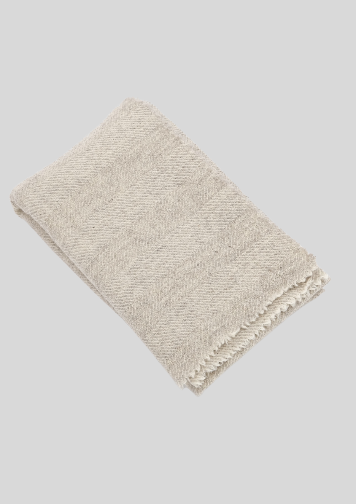Herringbone pattern white and light grey colored throw made out of responsible Finnish sheep wool. Manufactured in Finland.  
