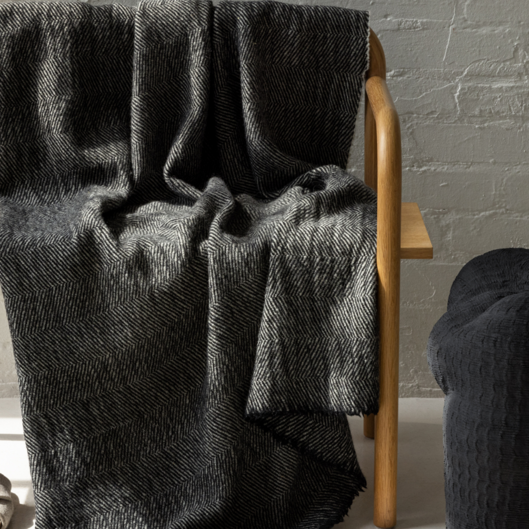 Luxury Finnish wool throw blanket in black and grey herringbone pattern